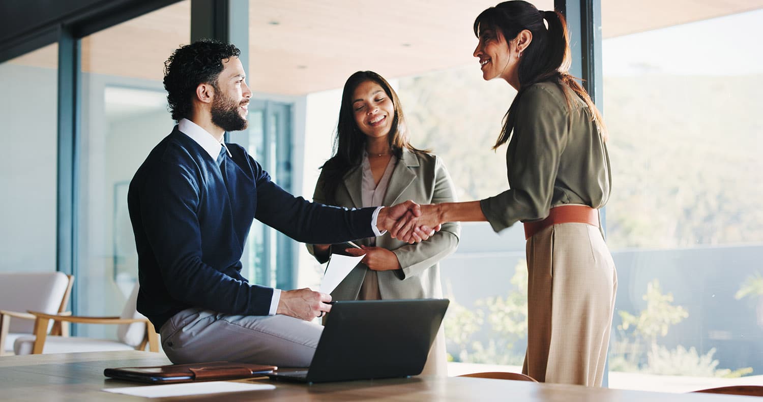Office, business people and handshake with team for welcome, greeting or introduction. Collaboration, shaking hands and happy workers in meeting for negotiation, b2b deal or thank you for partnership.