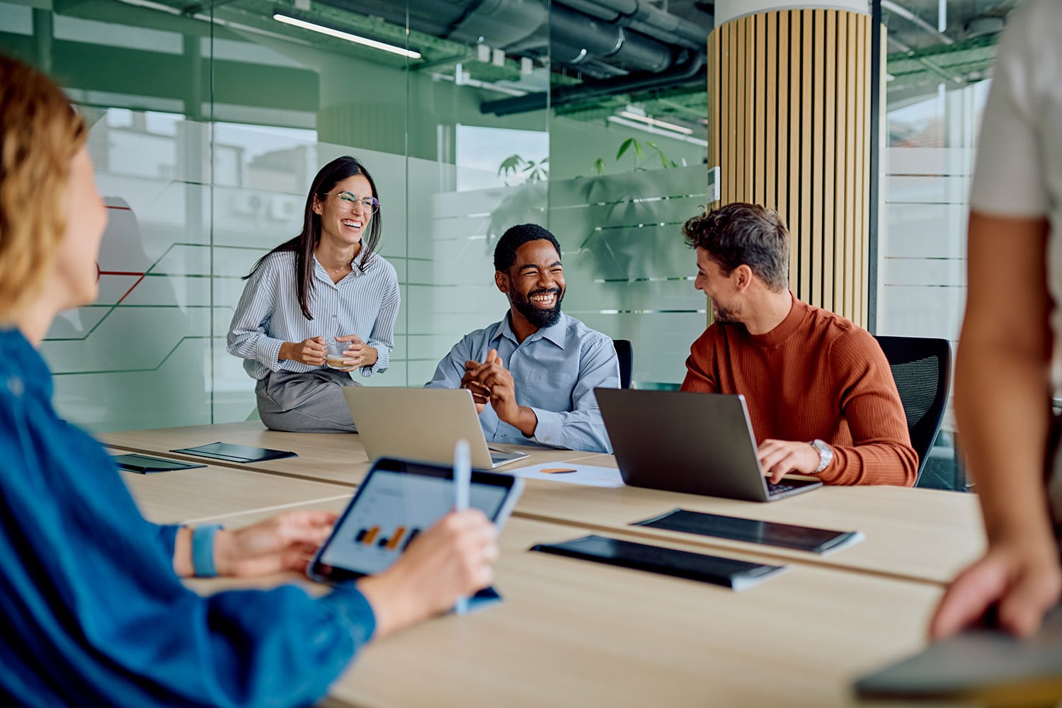 Diverse business team collaborating and laughing during office meeting
